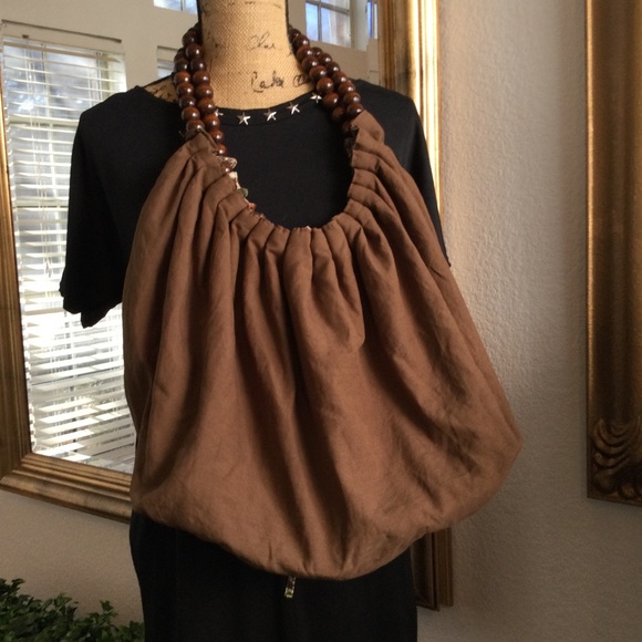 Reversible hobo tote with brown wood balls straps. Has a tie strap closure. - Picture 1 of 10